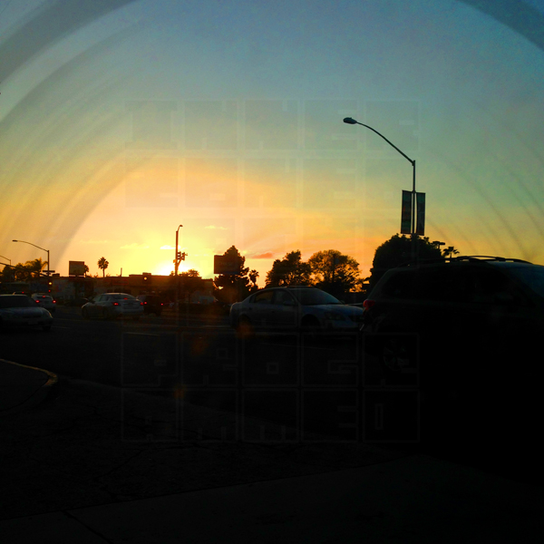 The sun sets on El Cajon Blvd., streetlights looming benign in the distance