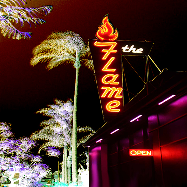 A negative image of the sign for The Flame nightclub (in Hillcrest), with palm trees swaying in the background