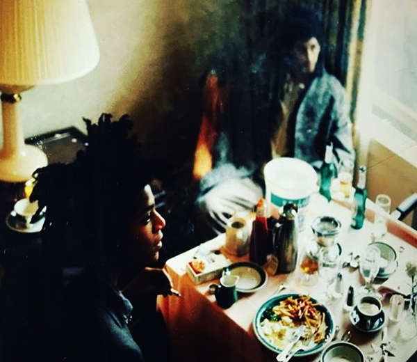 Jean-Michel Basquiat and Rammellzee sitting at a corner table