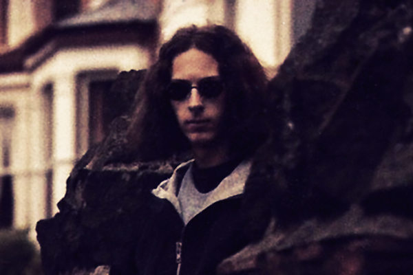 Early promo shot of Mike Paradinas, looking mysterious in shades and proggy shadows