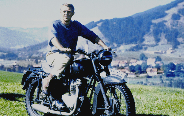 Steve McQueen rides a stolen motorcycle across the German countryside