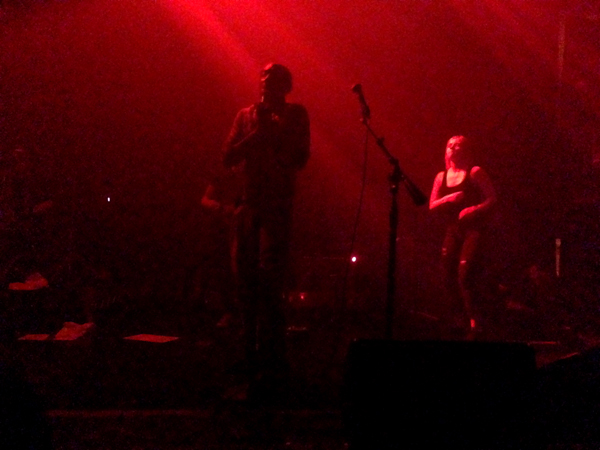 Tricky stands at center stage as Marta dances in the background